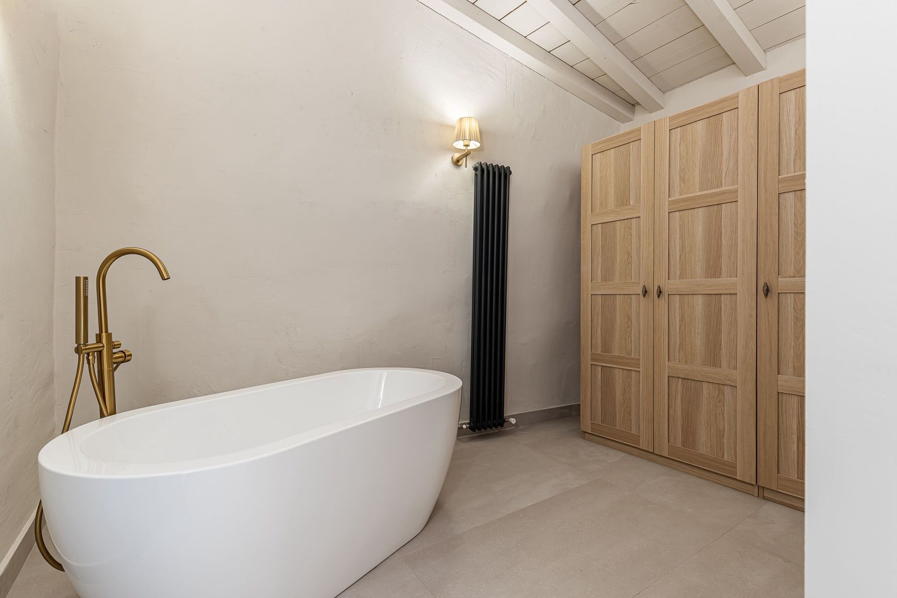 Baño con bañera exenta y grifería dorada