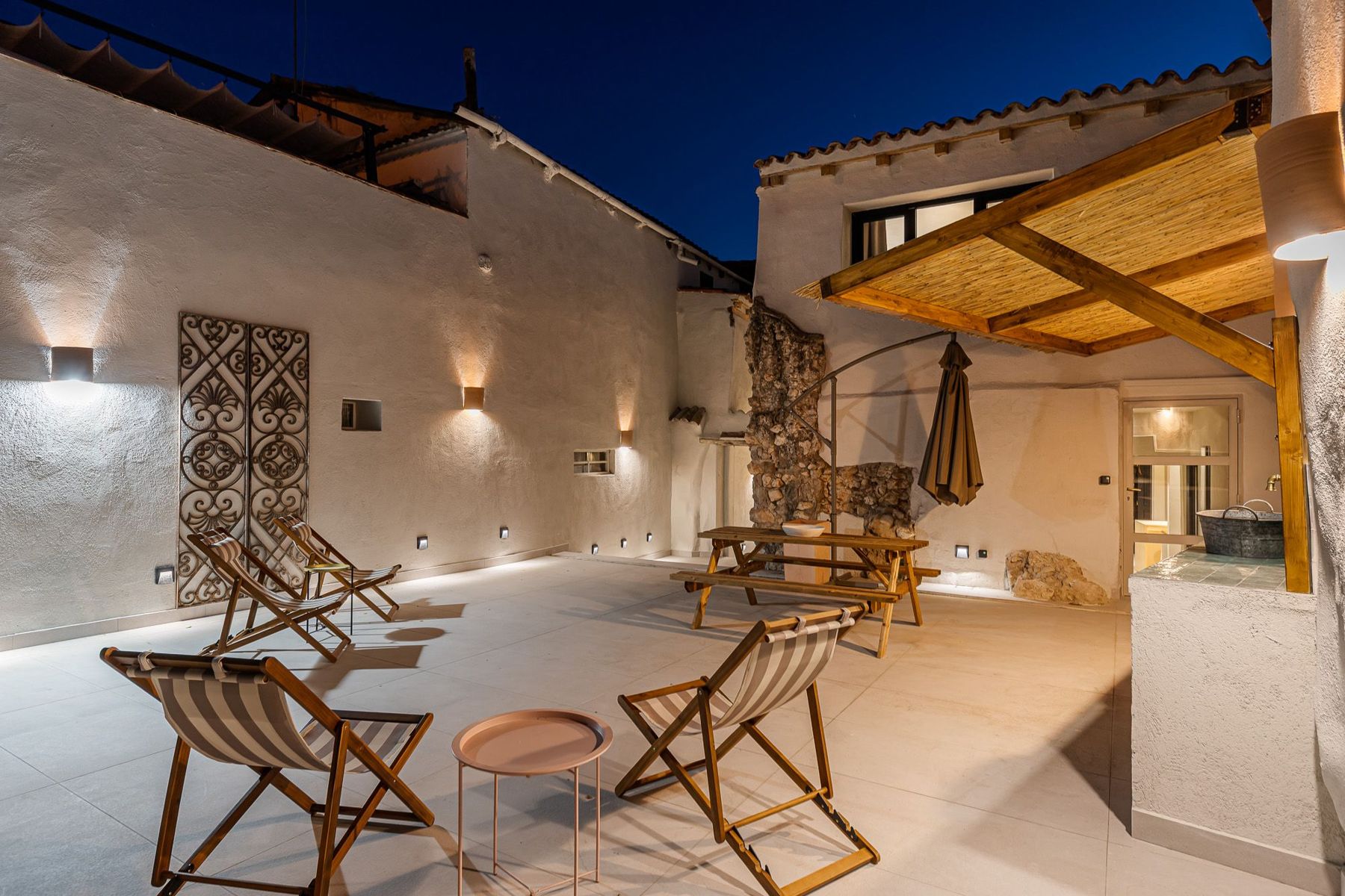 Patio con zona de estar iluminado de noche